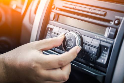 Woman,Turning,Button,Of,Radio,In,Car